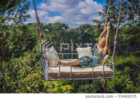 Young woman swinging in the jungle rainforest of Bali island, Indonesia. Swing in the tropics 55469335