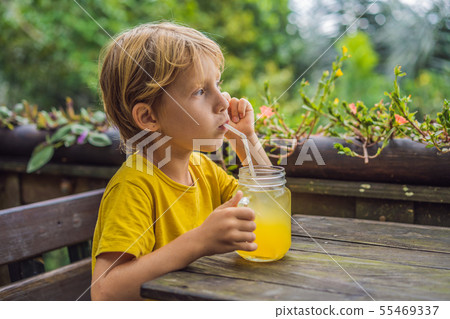Boy drinking juice in a cafe. What to do with children. Child friendly place Boy drinking juice in a cafe. What to do with children. Child friendly place 55469337