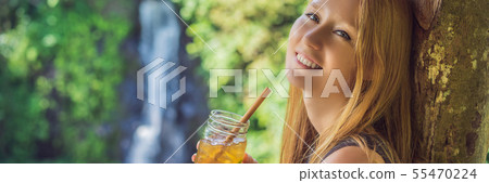 Closeup portrait image of a beautiful woman drinking ice tea with feeling happy in green nature and Closeup portrait image of a beautiful woman drinking ice tea with feeling happy in green nature and 55470224