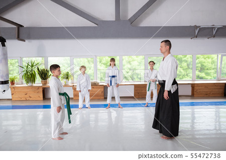 Boy standing in front of his aikido trainer before practicing 55472738