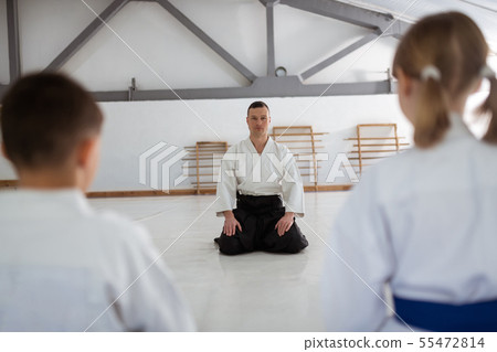 Trainer wearing black belt sitting in front of his pupils Trainer wearing black belt sitting in front of his pupils 55472814