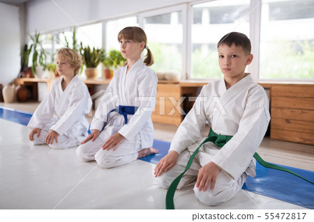 Three children feeling serious while learning aikido 55472817