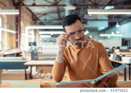 Man working in the publishers office looking at the book Man working in the publishers office looking at the book 55475051