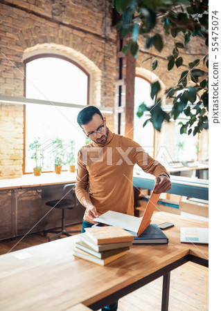 Handsome bearded writer standing in light spacious printing office 55475074