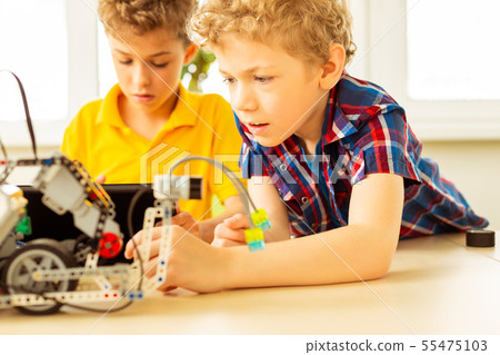 Smart blonde boy trying to construct a robot 55475103