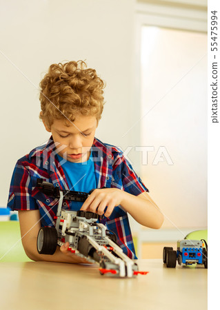 Serious cute boy enjoying his favourite hobby Serious cute boy enjoying his favourite hobby 55475994