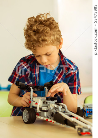 Intelligent cute nice boy constructing a car Intelligent cute nice boy constructing a car 55475995
