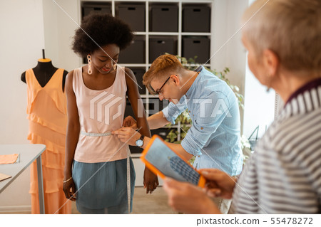 Smiling man bending over a pleased model 55478272