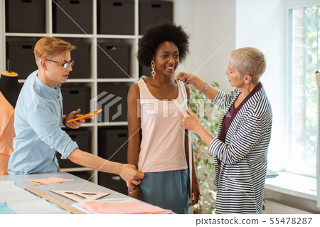 Model standing in the company of fashion designers 55478287