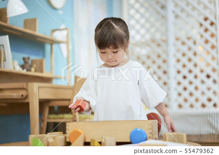 Girl playing blocks children room 55479362