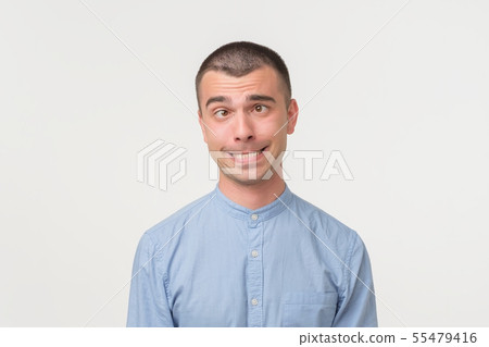 Handsome latino man shows surprised smile grimace Handsome latino man shows surprised smile grimace 55479416