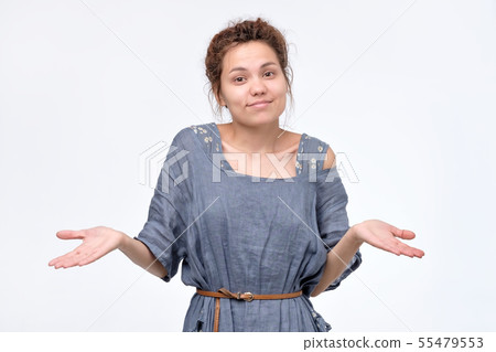 Shrugging ethnic woman in doubt doing shrug Shrugging ethnic woman in doubt doing shrug 55479553