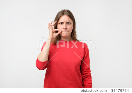 woman in red pulover showing silence sign woman in red pulover showing silence sign 55479734
