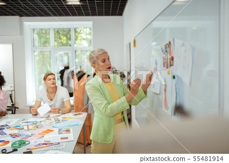 Serious aged blonde woman standing in a studio Serious aged blonde woman standing in a studio 55481914