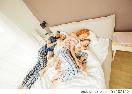 Nice positive family sleeping together in the bed 55482340