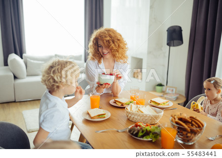 Delighted nice woman holding a bowl with strawberries Delighted nice woman holding a bowl with strawberries 55483441
