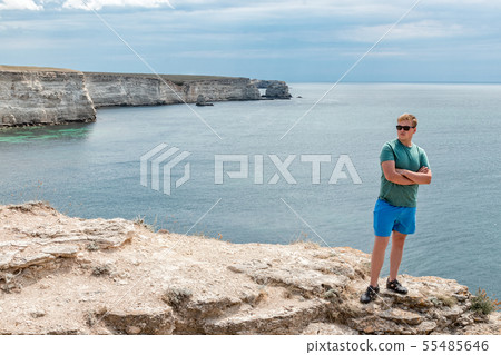 Happy young man on top of cliff enjoying view of 55485646