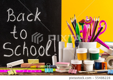 Stationery on a table in front of blackboard with Stationery on a table in front of blackboard with 55486228