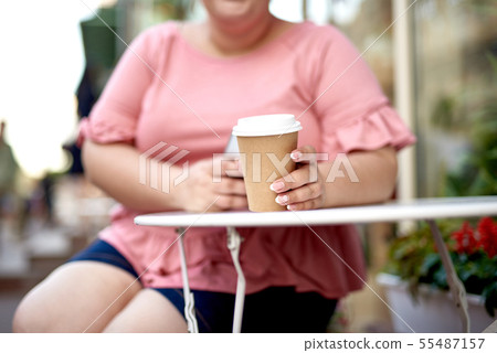 Young fat woman holding cup with beverage 55487157