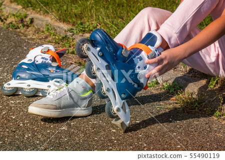 Girl putting on roller skates Girl putting on roller skates 55490119