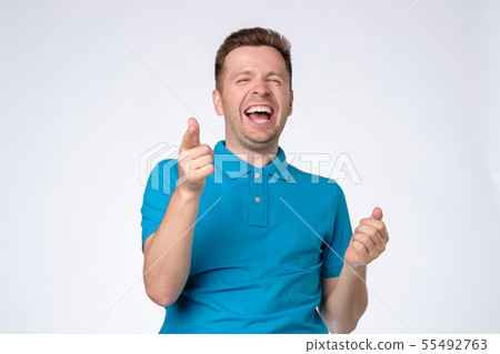 Handsome young man laughing at joke Handsome young man laughing at joke 55492763