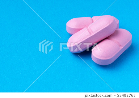 pink pills on a blue background. omega3. vitamins. pink pills on a blue background. omega3. vitamins. 55492765