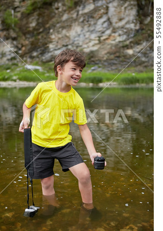 Smiling hooligan is watering digital camera. 55492888