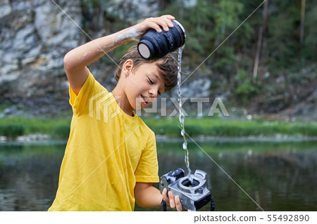 Cheerful boy is watering digital camera. 55492890