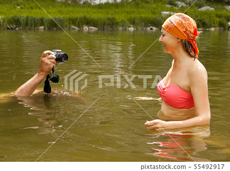 Taking photos of smiling woman in water. Taking photos of smiling woman in water. 55492917