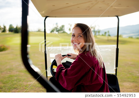 woman driving a buggy car on a meadow woman driving a buggy car on a meadow 55492953
