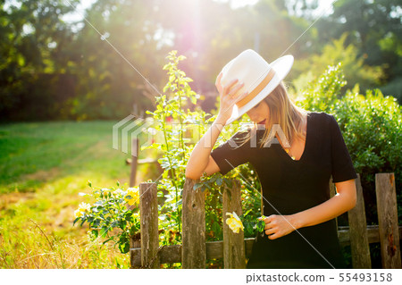 woman in hat in a summertime countryside garden woman in hat in a summertime countryside garden 55493158