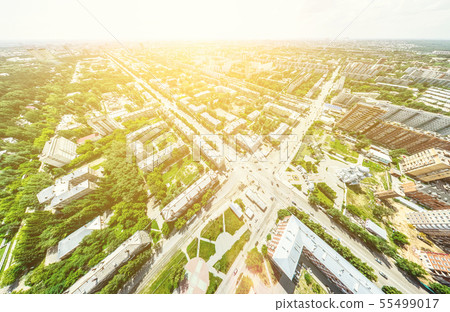 Aerial city view with crossroads and roads, houses, buildings, parks and parking lots. Sunny summer 55499017
