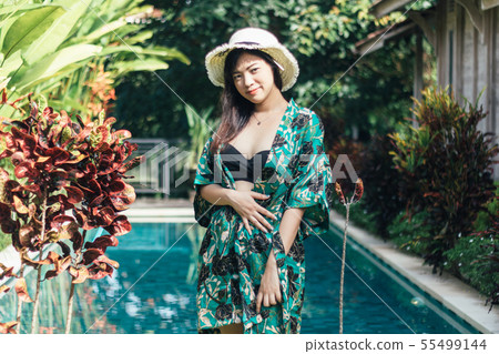 Pretty Asian woman is relaxing in the pool villa. Pretty Asian woman is relaxing in the pool villa. 55499144