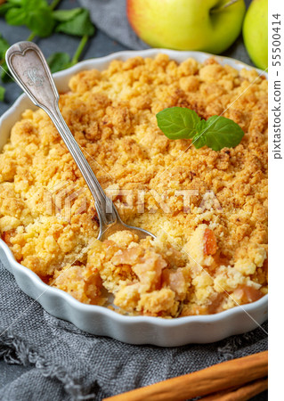 Apple crumble and a dessert spoon closeup. 55500414