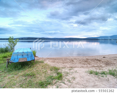 Dramatic evening sky above calm lake with stacked 55501162
