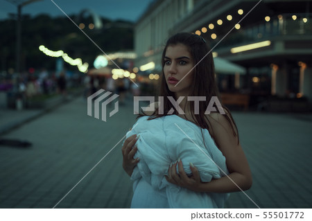 Sad woman wrapped in a white blanket. Sad woman wrapped in a white blanket. 55501772
