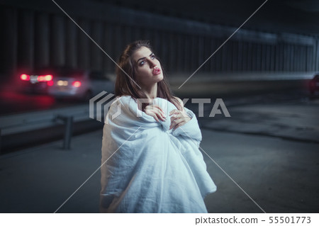 Woman wrapped herself in a blanket, she stands in Woman wrapped herself in a blanket, she stands in 55501773