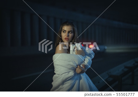 Beautiful woman wrapped herself in a white blanket Beautiful woman wrapped herself in a white blanket 55501777