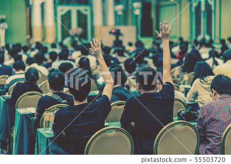 Rear view of Audience showing hand to answer the question from Speaker on the stage in the conference hall or seminar meeting, business and education concept 55503720