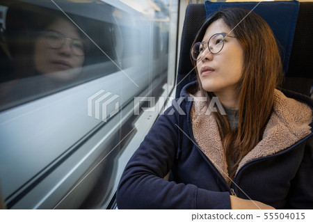 Asian Young lady passenger Sitting in a depressed mood beside the window inside Train which travel between town when travel alone for escape the chaos, traveller and depress concept Asian Young lady passenger Sitting in a depressed mood beside the window inside Train which travel between town when travel alone for escape the chaos, traveller and depress concept 55504015