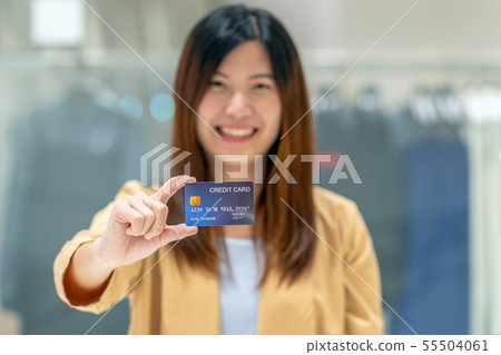 Portrait Asian woman holding and presenting the credit card for online shopping in department store over the clothes shop store, technology money wallet and online payment concept, credit card mockup Portrait Asian woman holding and presenting the credit card for online shopping in department store over the clothes shop store, technology money wallet and online payment concept, credit card mockup 55504061
