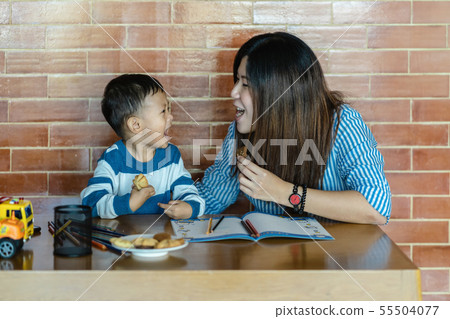 Asian single mom with son are drawing and eating cookie together when living in loft house for Self learning or home school, Family and single mom concept, selective focus Asian single mom with son are drawing and eating cookie together when living in loft house for Self learning or home school, Family and single mom concept, selective focus 55504077