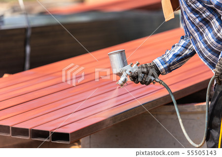 Worker spraying paint to steel pipe to prevent the rust on the surface Worker spraying paint to steel pipe to prevent the rust on the surface 55505143