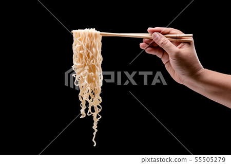Hand holding bamboo chopsticks and fork over instant noodles 55505279