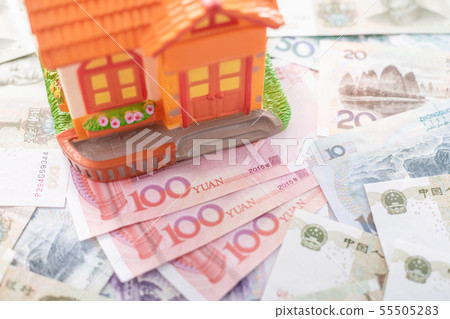 Buy or rental the house concept. Close up several banknote currency Chinese Yuan (CNY or RMB) and house model 55505283