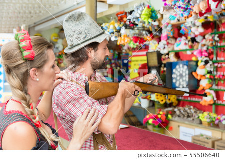 Couple on Bavarian fair at the shooting gallery 55506640