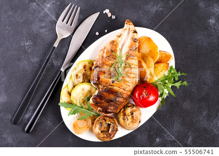 Grilled chicken breast on a plate with tomatoes, mushrooms on a stone background, flat lay Grilled chicken breast on a plate with tomatoes, mushrooms on a stone background, flat lay 55506741