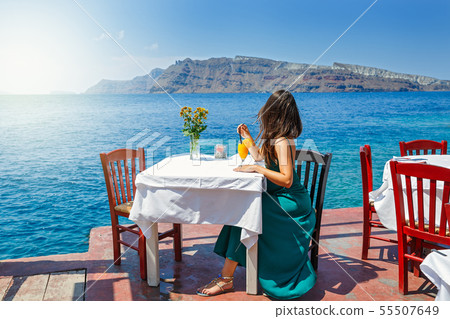 Young woman in a restaurant by the sea Young woman in a restaurant by the sea 55507649