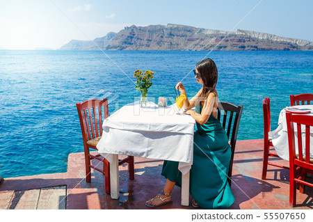 Young woman in a restaurant by the sea Young woman in a restaurant by the sea 55507650