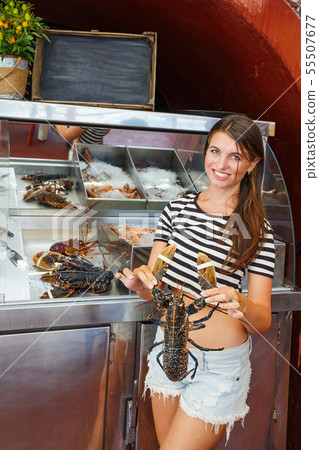 Woman at the window of a fish shop 55507677